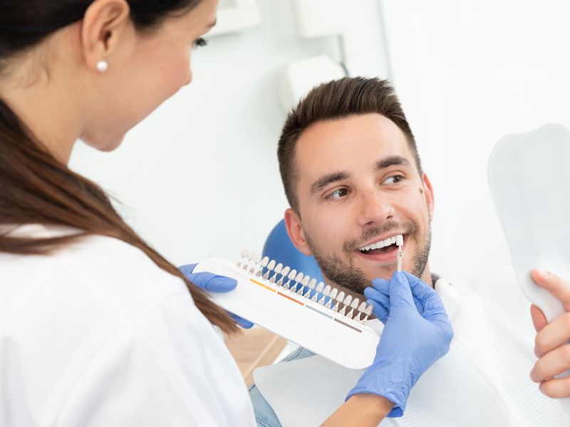 dentista  y paciente eligiendo tonos para blanqueamiento dental
